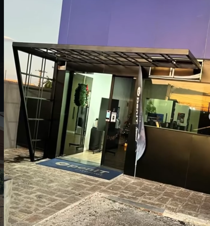 Cobertura metálica e portão pivotante em fachada comercial